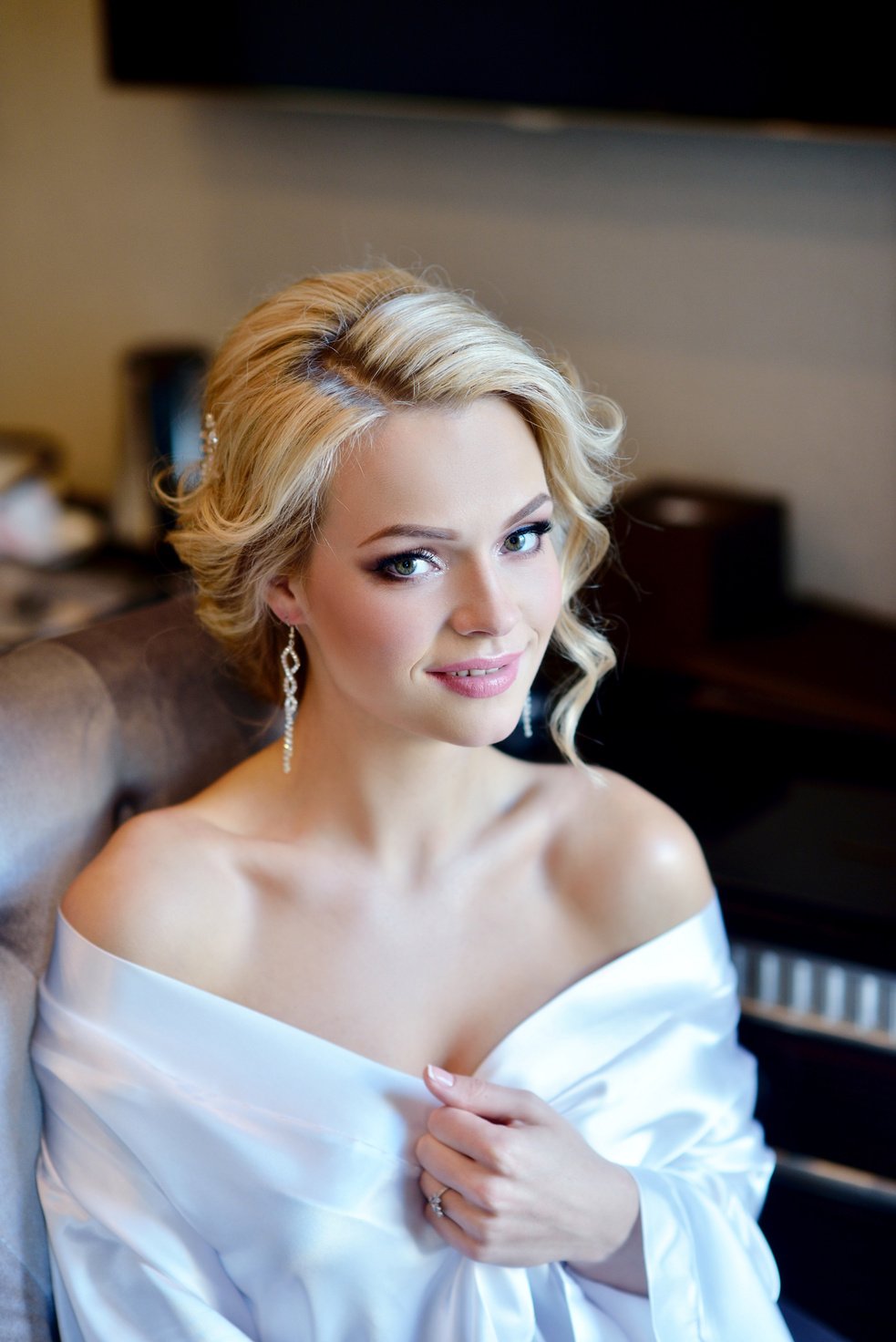 Beauty bride in dressing gown with bridal makeup indoors